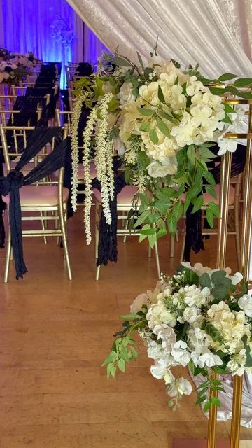 Arreglo floral blanco junto al pasillo de ceremonia